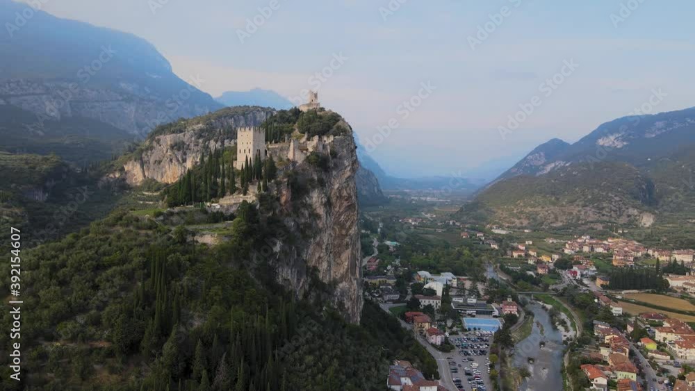 Aerial view or Arco castle, Riva del Garda, Italy. Old fortress on steep cliff, drone shot on summer day Aerial view or Arco castle, Riva del Garda, Italy. Old fortress on steep cliff, drone shot on summer day