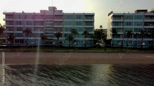 Low sideways along luxury beachside apartments at sunrise in SE Asia photo