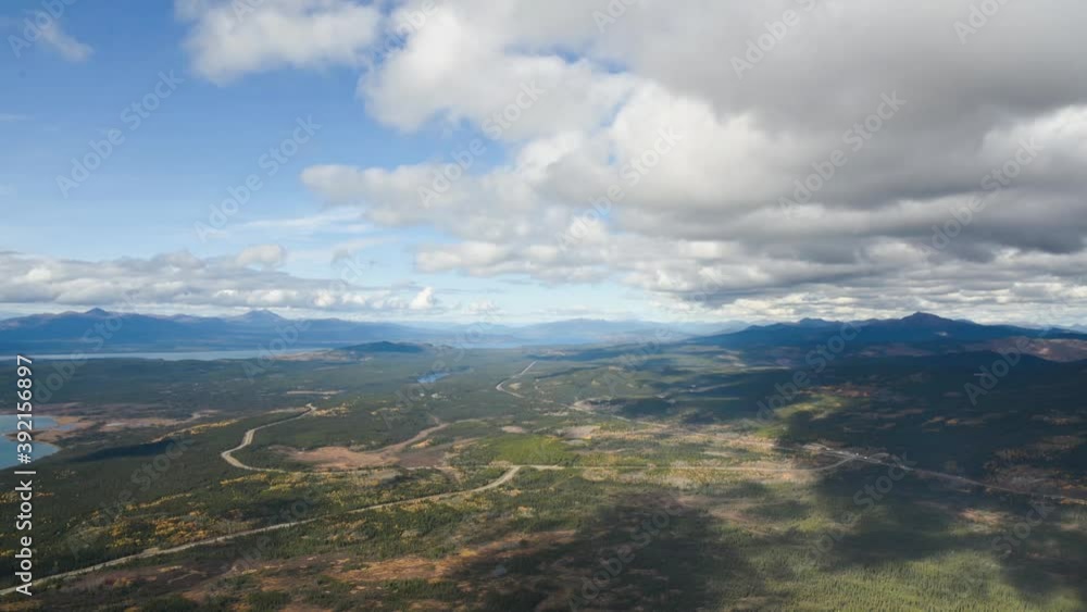 A timelapse from a mountain top with huge lake below featuring moving clouds, grey skies, woods and wilderness below. Taken in fall from Yukon Territory, northern Canada. A timelapse from a mountain top with huge lake below featuring moving clouds, grey skies, woods and wilderness below. Taken in fall from Yukon Territory, northern Canada.