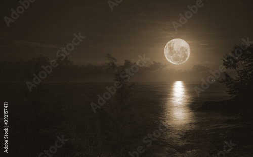 The full moon shines brightly on the water surface. © Chewcharn