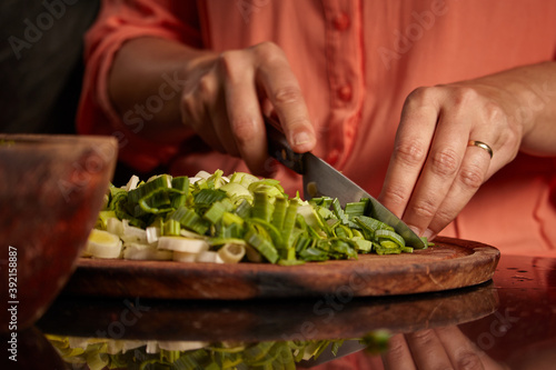 Closeup shot of a woman chopping green onion