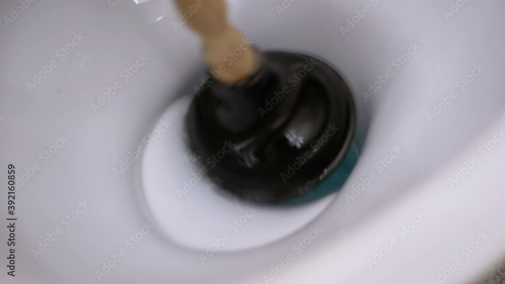 Male Hand Cleans toilet with Plunger of Hand Pump. Clear Blockage, Pollution Male Hand Cleans toilet with Plunger of Hand Pump. Clear Blockage, Pollution