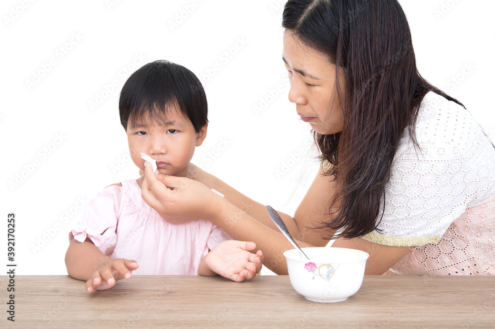 The young mother is wiping her mouth for the child who has eaten