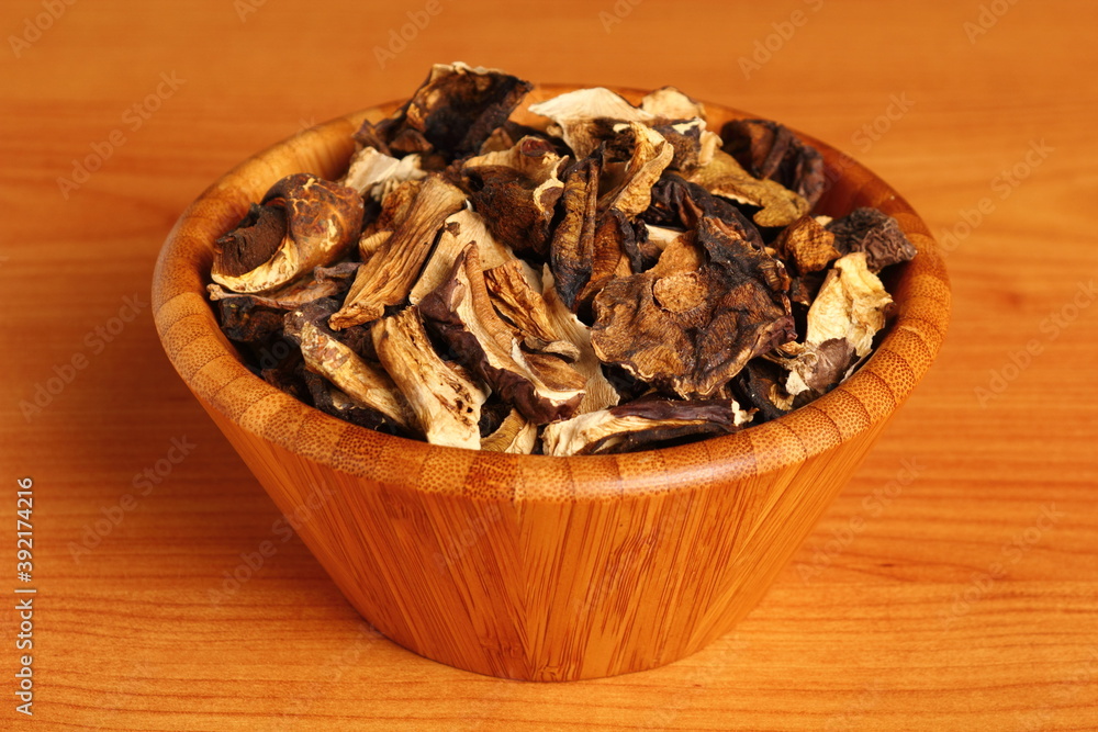 Dried mushrooms in wooden bowl. Boletus badius. Dried mushrooms in wooden bowl. Boletus badius.