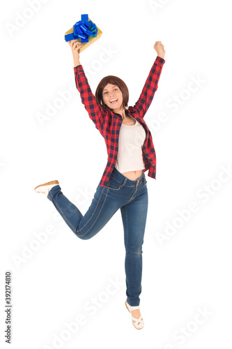 Happy full length young girl in red checked shirt with short hair jumps for joy when receiving gift: successful purchase, happiness, smile and joy are isolated on white background