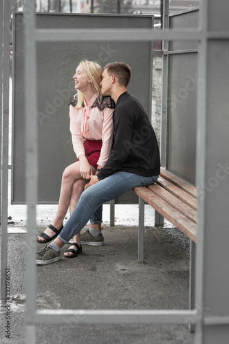 Young couple sitting at bench at bus stop