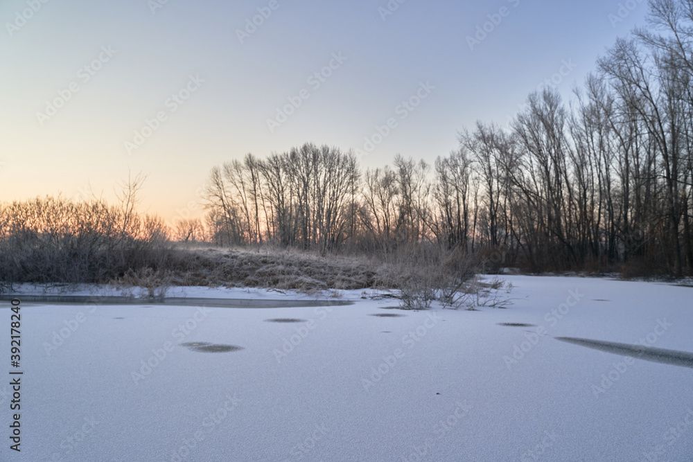 Breath of winter, first ice on the lake, dawn on a frosty morning with frost on the grass, close-up of frost, patterns on the first ice. Breath of winter, first ice on the lake, dawn on a frosty morning with frost on the grass, close-up of frost, patterns on the first ice.