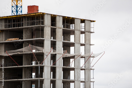 multi-storey building under construction against a gray sky © KseniyaK
