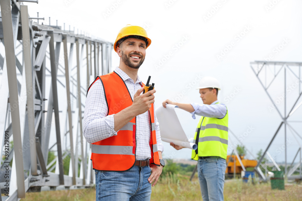 Professional engineers working on installation of electrical substation outdoors Professional engineers working on installation of electrical substation outdoors