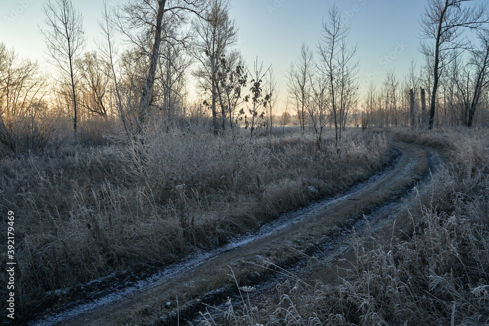 Breath of winter, first ice on the lake, dawn on a frosty morning with frost on the grass, close-up of frost, patterns on the first ice. Breath of winter, first ice on the lake, dawn on a frosty morning with frost on the grass, close-up of frost, patterns on the first ice.