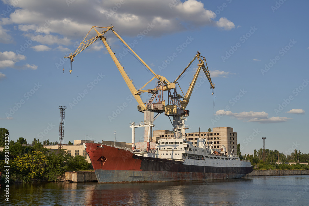 old and abandoned metal vessel in Mykolaiv Ukraine. rusted metal. old ship and cranes