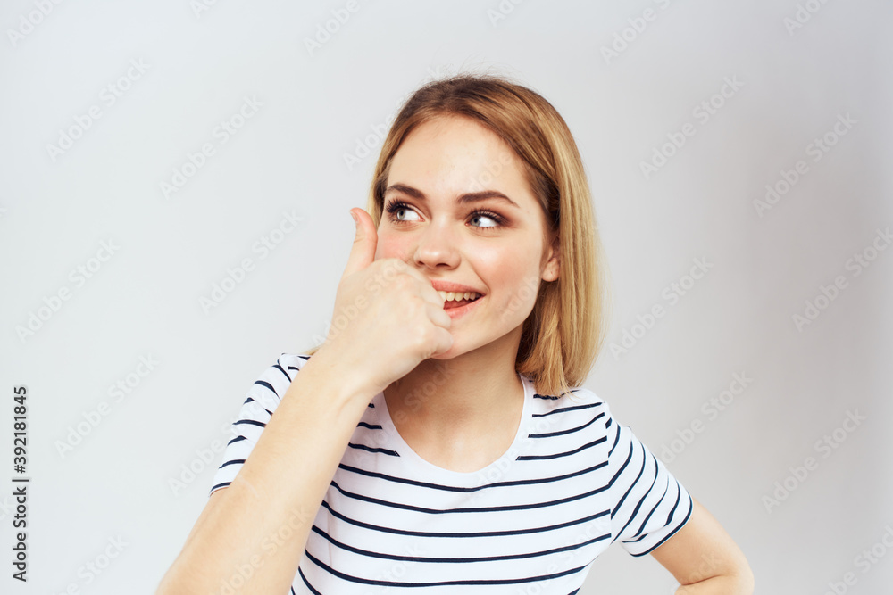 emotional woman in striped t-shirt gesture with hands lifestyle light background emotional woman in striped t-shirt gesture with hands lifestyle light background