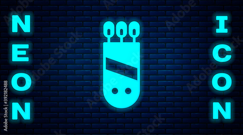 Glowing neon Quiver with arrows icon isolated on brick wall background. Vector.