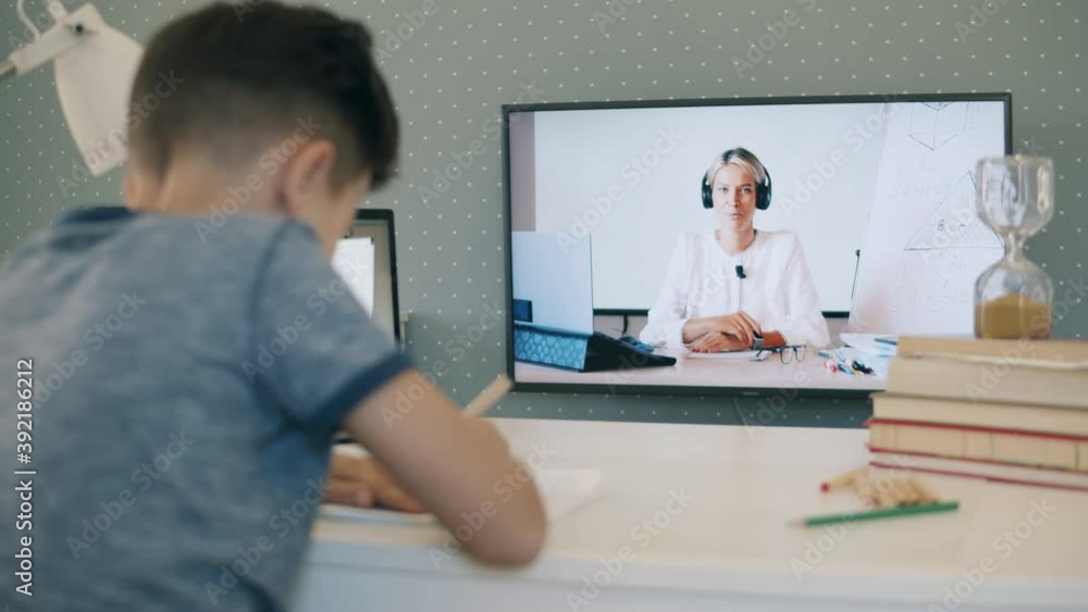 Little schoolboy studying remotely from home using his TV Little schoolboy studying remotely from home using his TV