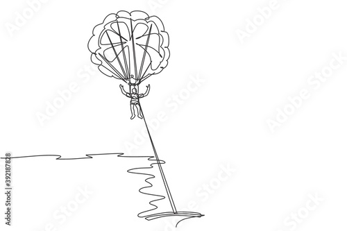 One single line drawing of young sporty man flying with parasailing parachute on the sky pulled by boat graphic vector illustration. Extreme sport concept. Modern continuous line draw design