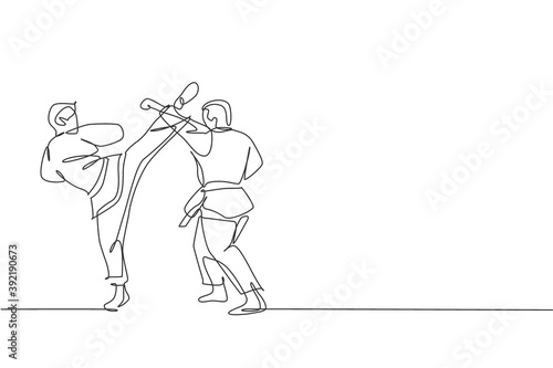 Single continuous line drawing two young confident karateka men in kimono practicing karate combat at dojo. Martial art sport training concept. Trendy one line draw graphic design vector illustration