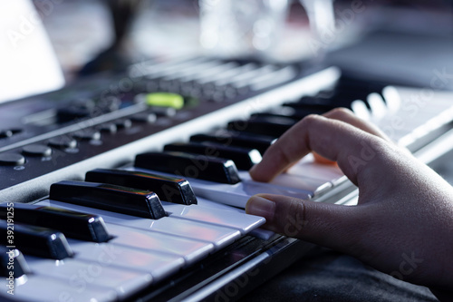 Selective focus of piano or keyboard with human hand