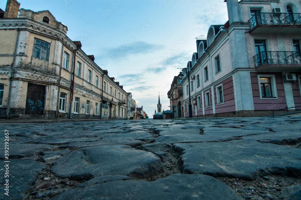 Street in the oldn town with close up on the old stone pavement. Selective focus, low DOF