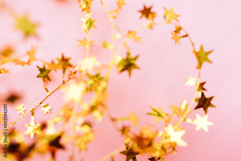 Blurred Golden star sprinkles on pink. Festive holiday background. Celebration concept. Top view, flat lay. Horizontal Blurred Golden star sprinkles on pink. Festive holiday background. Celebration concept. Top view, flat lay. Horizontal