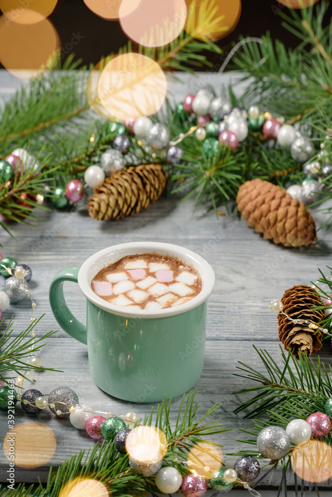 A mug of cocoa with marshmallows on a table with Christmas decor