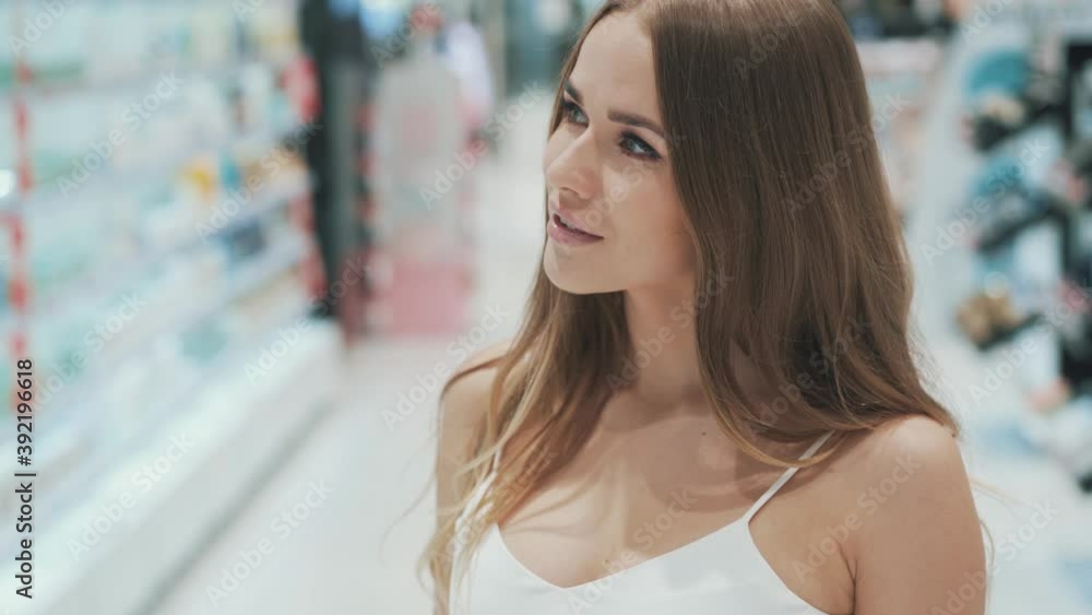 Beautiful flirtatious smiling charming caucasian girl is choosing beauty product Beautiful flirtatious smiling charming caucasian girl is choosing beauty product