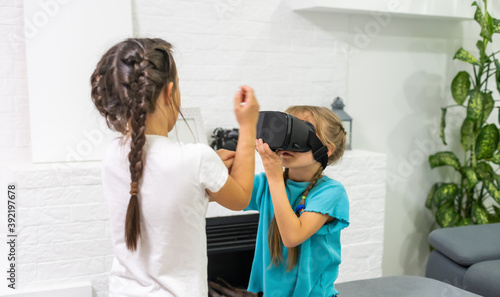 two little girls using glasses of virtual reality headset. concept of modern technologies