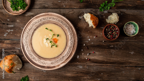 Chicken Cream Soup. Traditional recipe cheese soup with pea sprouts in bowl on wooden background. Food recipe background. space for text. top view