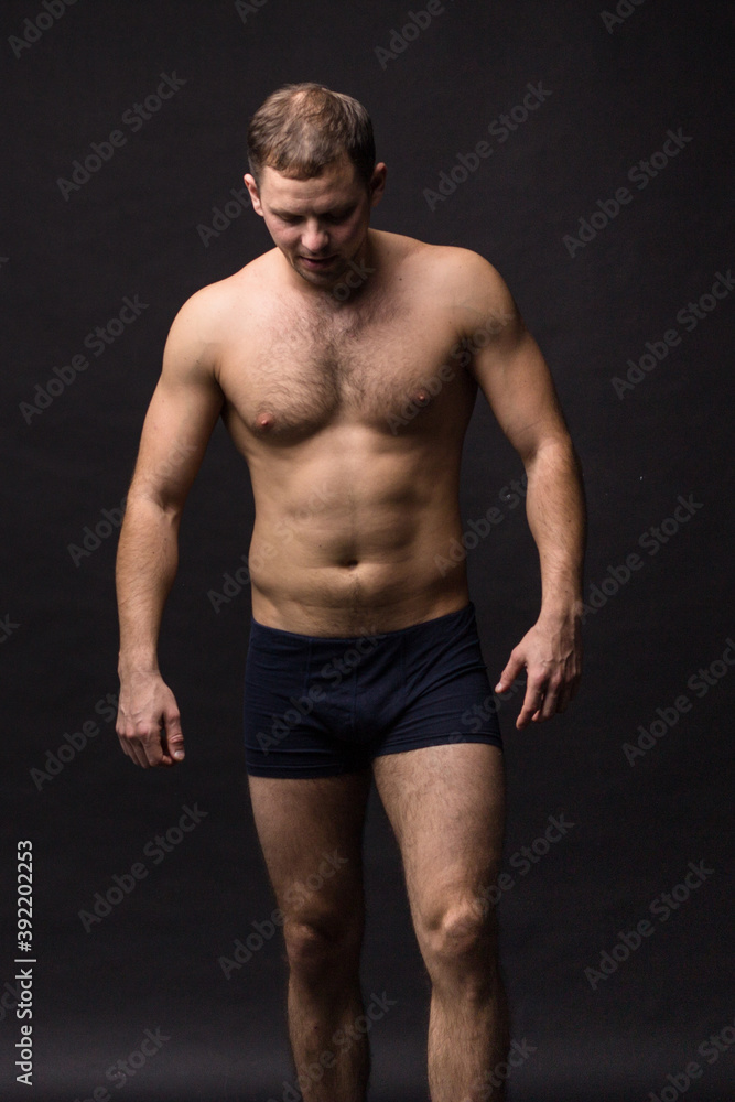 Fototapeta premium Handsome man in underwear on the black background. Muscular and athletic. Underwear man portrait. Male underwear model in studio