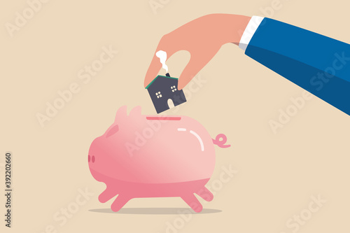 Saving for house, mortgage or housing loan, collect money for down payment concept, human man holding warm family house insert into pink piggy bank.