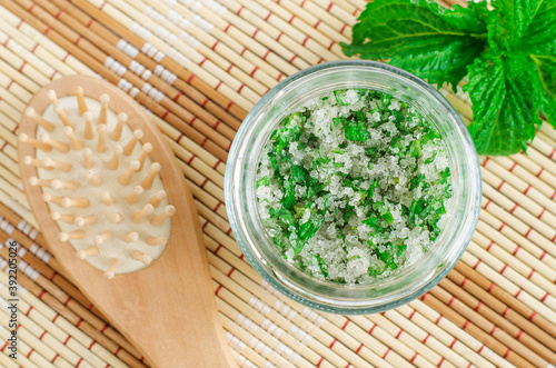 Homemade mint exfoliating scrub (scalp peeling, bath salt, foot soak) with sugar, chopped mint leaves, olive oil and essential mint oil. Natural skin and hair care. DIY beauty treatments, spa recipe. 