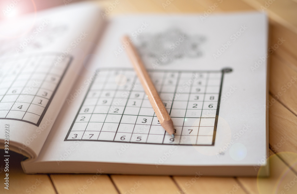 sudoku (crossword) puzzle and pencil. Selective focus. sudoku (crossword) puzzle and pencil. Selective focus.