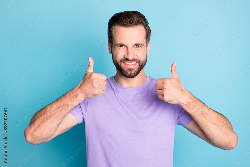 Photo of young attractive man show thumbs-up ad promo like perfect choice isolated over blue color background Photo of young attractive man show thumbs-up ad promo like perfect choice isolated over blue color background