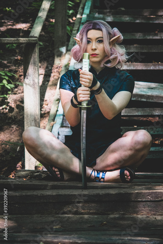 An elven girl with a katana in her hands is walking through the forest and preparing for battle