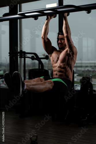 Man Performing Hanging Leg Raises Exercise