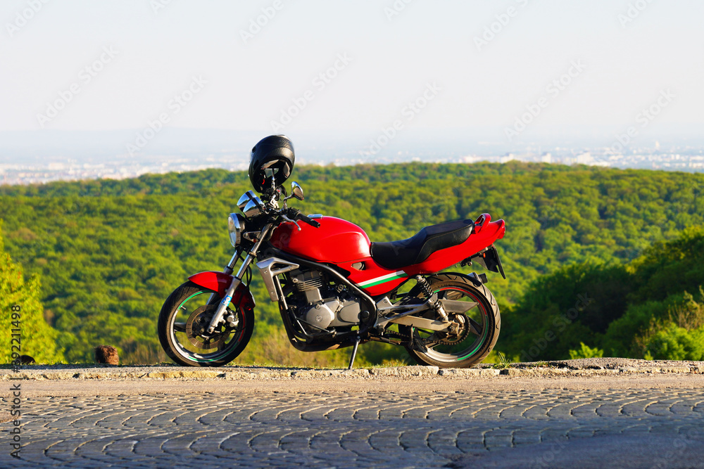 Ein rotes sportliches Motorrad auf Hügel am Rand von Wien an einem sonnigen Tag