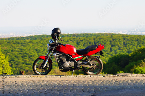 Ein rotes sportliches Motorrad auf H  gel am Rand von Wien an einem sonnigen Tag
