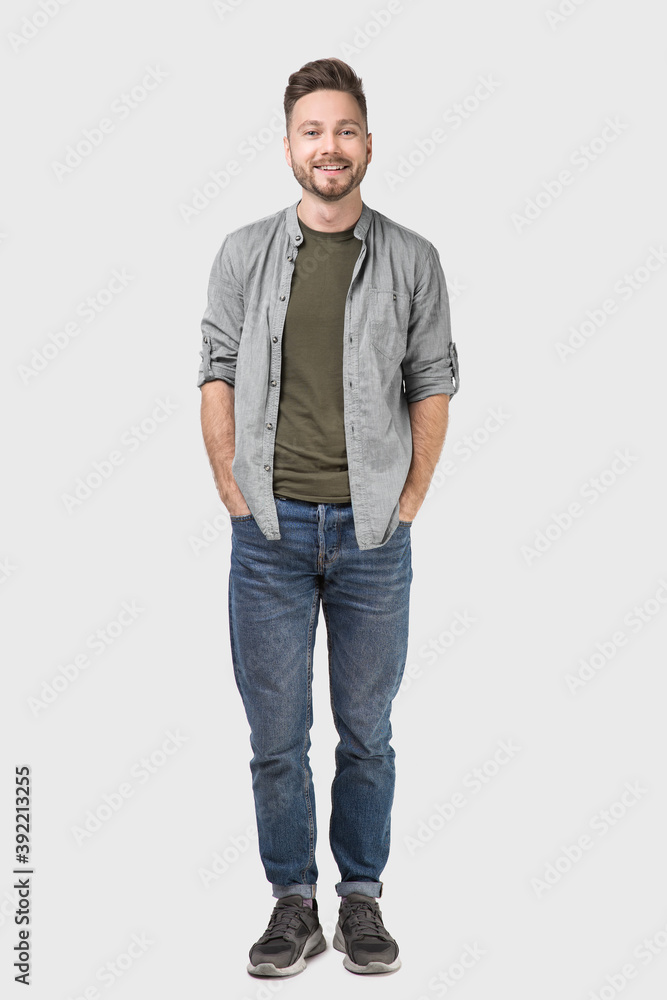 Full length portrait of handsome smiling young man, laughing joyful cheerful men isolated studio shot Full length portrait of handsome smiling young man, laughing joyful cheerful men isolated studio shot