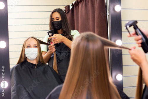 young woman at hairdresser wearing protective mask due to coronavirus pandemic