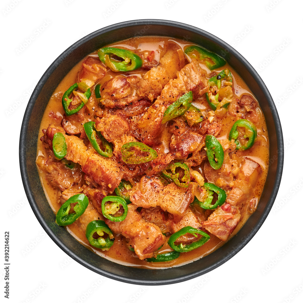 Bicol Express Stew in black bowl isolated on white. Filipino cuisine spicy pork belly coconut milk curry. Asian food.
