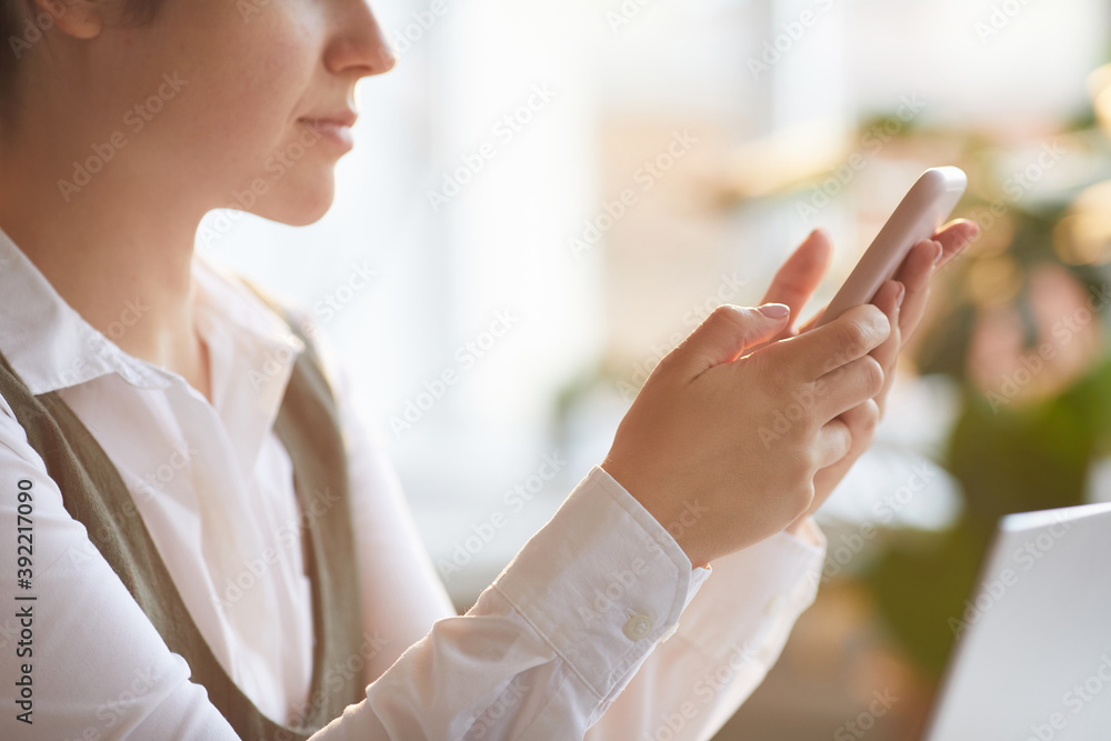 Close-up of woman holding mobile phone and typing a message on it Close-up of woman holding mobile phone and typing a message on it