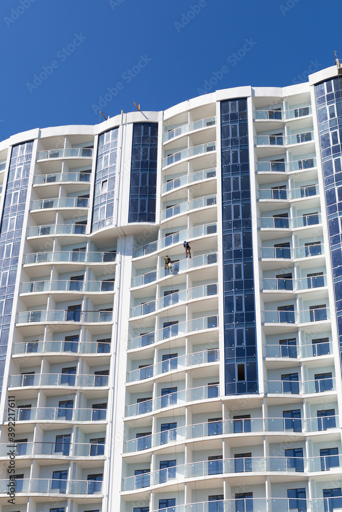 Constructing skyscraper over blue sky, modern architecture.