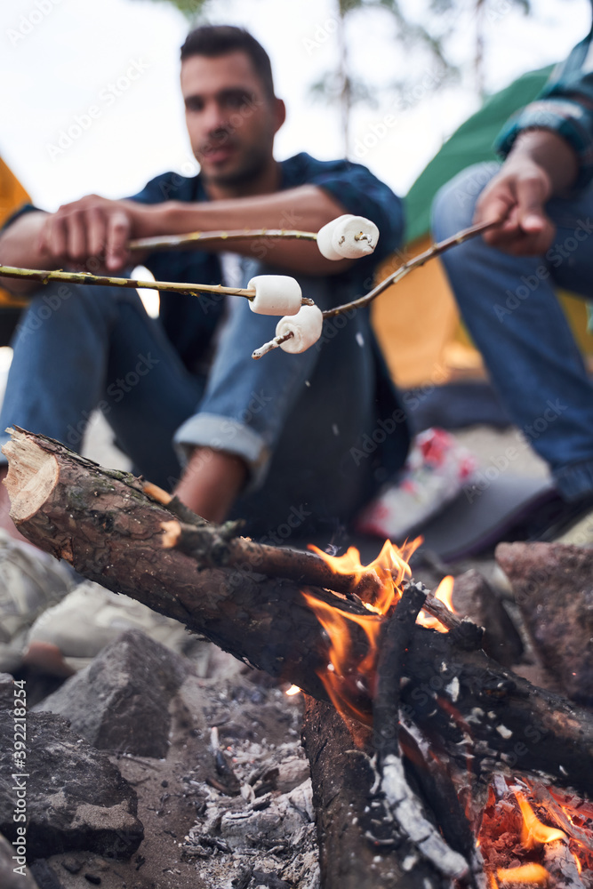 Fototapeta premium Guys frying marshmallows at the forest