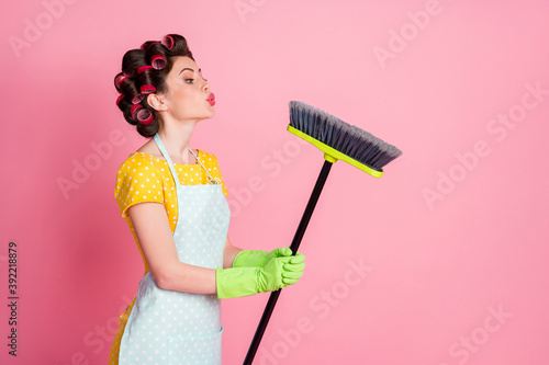Slika na platnu Portrait of nice attractive brown-haired maid holding in hand broom sending air