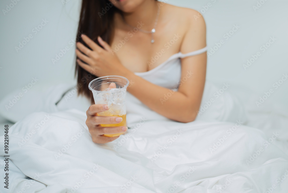 A sexy woman eating liquor or beer in a white bed of plastic glasses.