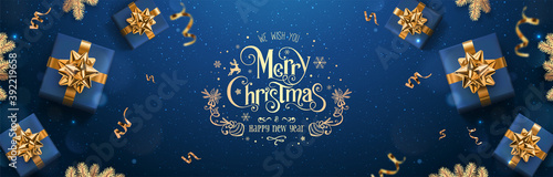 Gold Merry Christmas and New Year text on dark blue background with Christmas gift boxes  golden fir branches  ribbons  decoration  confetti  bokeh. Xmas card. Vector  holiday realistic banner
