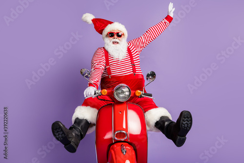 Photo of carefree santa claus ride retro bike wear x-mas costume striped shirt headwear sunglass isolated violet color background