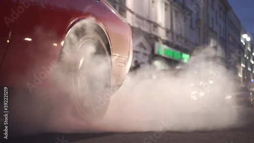 Car burns rubber off its tires in preparation for the race. Footage. Slow motion video of sport vehicles right back wheel the tire burns against the asphalt with smoke
