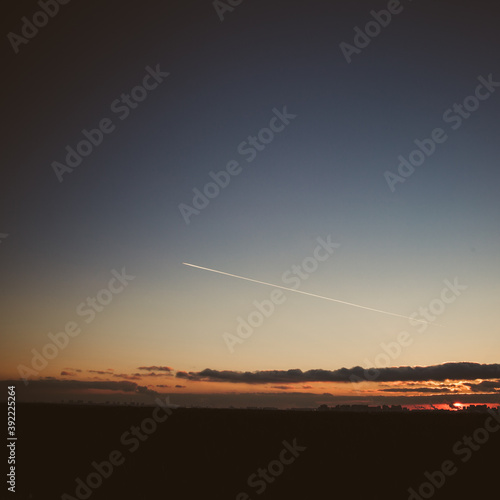 Beautiful sky and a plane flying by at sunset