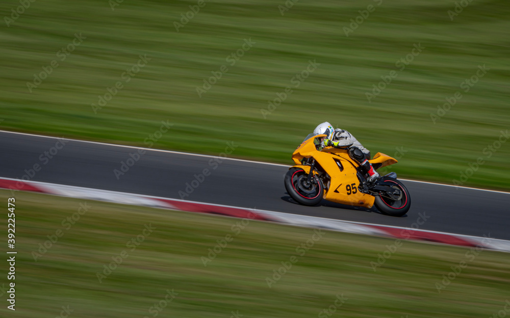 A panning shot of a racing bike cornering on a track.