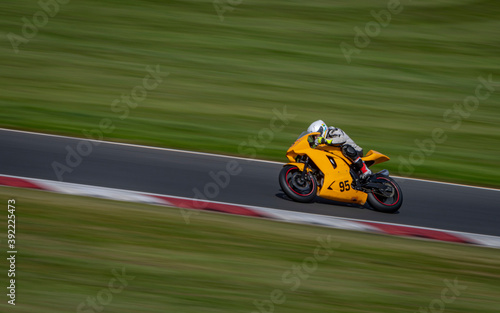 A panning shot of a racing bike cornering on a track. © SnapstitchPhoto